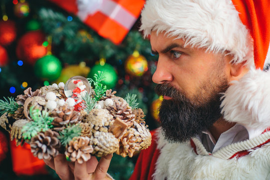Santa Claus portrait. A man in a Santa Claus hat looks at the Christmas decorations. December mood.