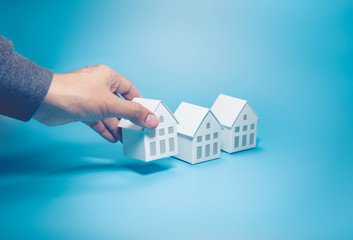 Business property,real estate and investment concepts with male hand and white model house on...