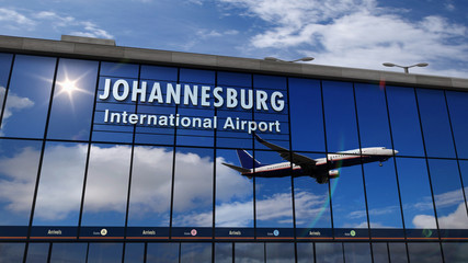 Fototapeta premium Samolot lądujący w Johannesburgu odbity w terminalu