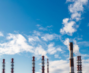 Pipes of a Plant from which there is Smoke Against the Blue Sky on a Sunny Day.