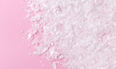 White artificial snow on pink background with copy space