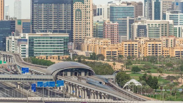 Dubai Golf Course with a cityscape of Gereens and tecom districts at the background aerial timelapse. Traffic on sheikh zayed road with junction and metro starion