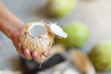 Close-up of Men hand holding open coconut milk cocktails.