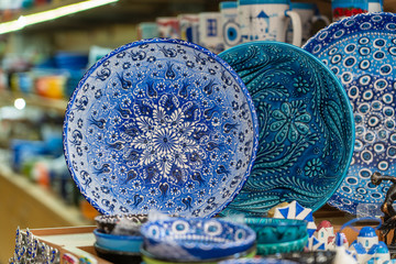 Traditional colorful greek souvenir ceramic plate for sale for tourists in a street shop, closeup. Kos island, Greece.