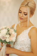 Naklejka premium Portrait of gorgeous bride at home. Charming woman with bouquet. Morning of beautiful bride. Wedding day