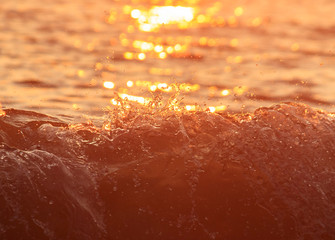 Wave splashes against the sea shore in sunlight