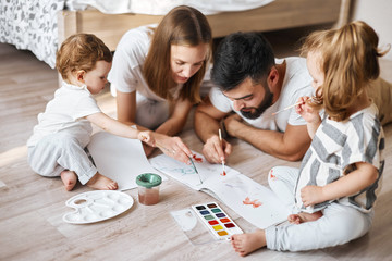 young parents studing with children , developing their painting skills, close up photo