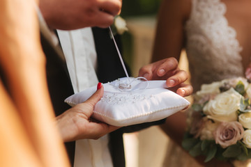 Close up of hands groom and bride wearing a ring