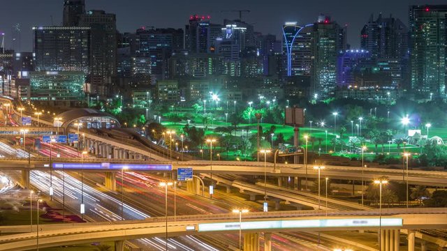 Dubai Golf Course with a cityscape of Gereens and tecom districts at the background aerial night timelapse. Traffic on sheikh zayed road with junction