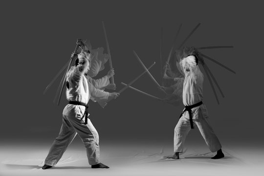 Two caucasian men are practicing aikido with the bokken