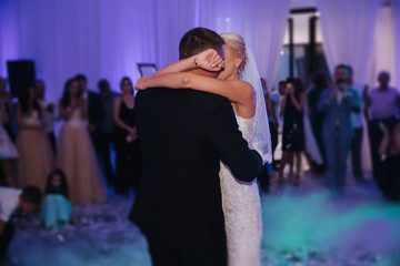 Portrait of first dance of stylish wedding couple. Handsome groom and elegant bride in the restaurant