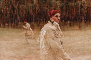 Multiple exposure. Traveler in a raincoat and a red knitted hat. Loneliness. Psychology