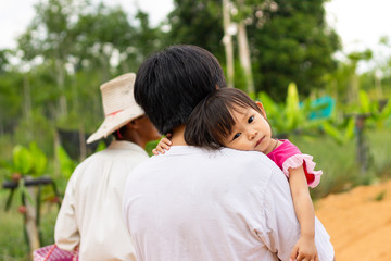 Obraz premium Asian​ Father​ is​ holding his little​ daughter​ on his shoulders. Love​ and​ family​ concept.
