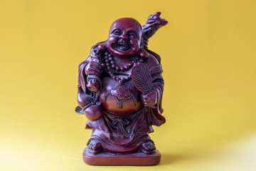 Statuette en résine d'un bouddha qui rit sur fond jaune