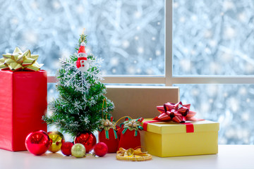 Winter celebration, Christmas tree decorated with ornaments next to window glass.