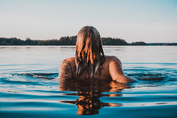 Finnish Girl in a Lake swimming, blue, Finland, summer