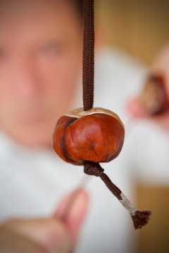 Cuacasian boy playing a game of conkers