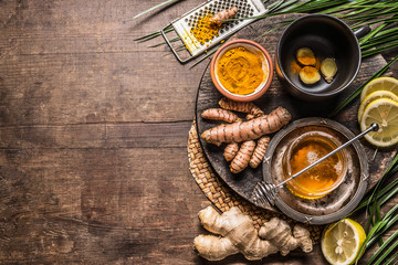 Fototapeta na wymiar Turmeric ginger tea preparation with healthy ingredients on rustic wooden background, top view