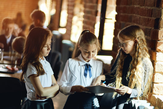 three clever girls conentrated on paperwor, close up photo.girls brainstorming while standing next to the window