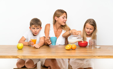 Obraz na płótnie Canvas Mother with her two children having breakfast