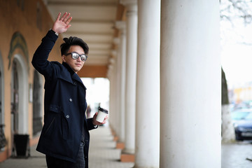 Obraz premium Asian young man in a coat on the street