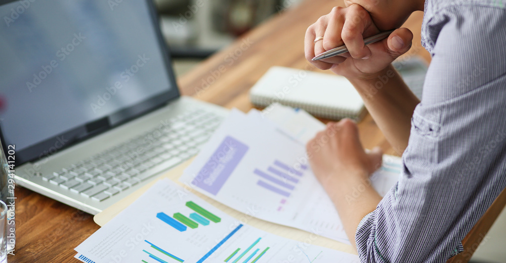 Fototapete side view of experienced businessman looking at financial data with graphics and charts while work o