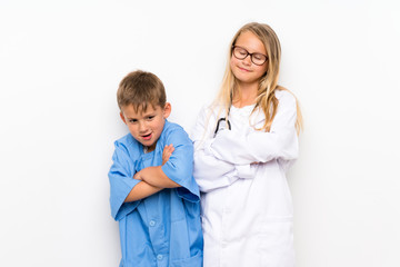 Little brothers playing to be doctors  over isolated white wall