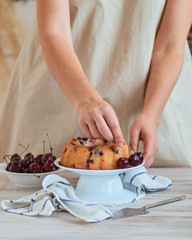 Woman hand decorated homemade lemon cake with blueberries. rustic style