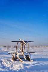 Farm equipment on winter meadow in daylight