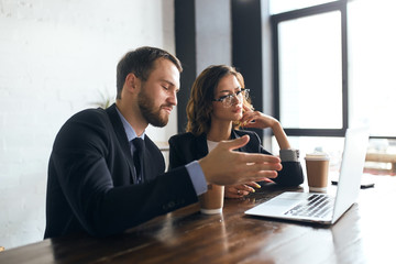 active ambitious man presenting his successful project to a colleague during lunch time at the cafe with panorama window, close up photo