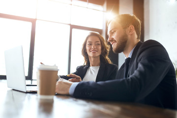 beautiful woman admires his clever colleague who is fixing her broken computer. close up photo.