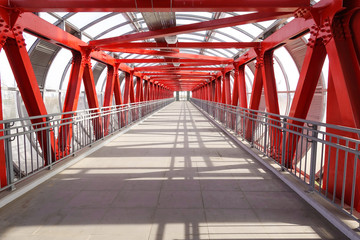 Long overpass over the road. Metal constructions. Red painted metal.