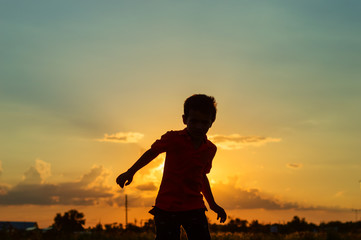 Fototapeta premium Silhouette of a boy against the backdrop of the setting sun