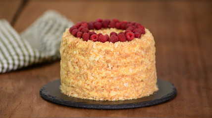 Napoleon layered cake with berries on a wooden table.