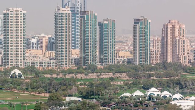 Dubai Golf Course with a cityscape of Gereens and tecom districts at the background aerial timelapse. Top view from Dubai marina