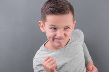 Handsome brunette boy run over grey background