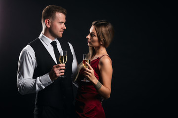 attractive couple drinking wine, talking, having a conversation isolated black background, studio shot, love, relationship, date, copy space