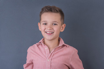 cute school boy in peach shirt smiling