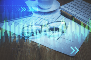 Financial chart hologram with glasses on the table background. Concept of business. Double exposure.