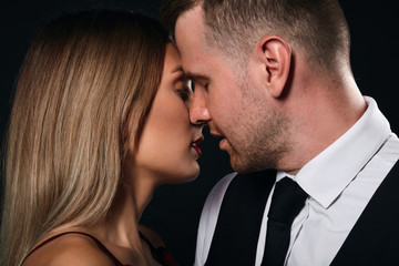 close up cropped photo. young couple kissing, closeness, isoltated black background, sstudio shot.