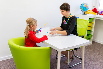 Elementary Age Girl in Child Occupational Therapy Session Doing Playful Exercises With Her...