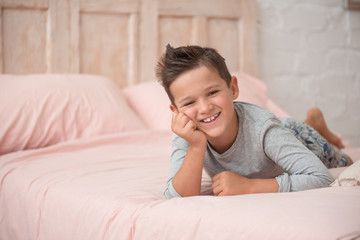 Funny brunette boy cute in his bed
