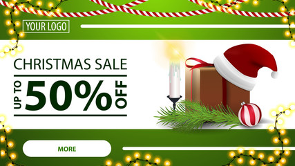 Christmas sale, up to 50% off, green horizontal modern web banner with button, garland, gift with Santa Claus hat, candles, Christmas tree branch and Christmas ball