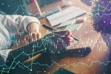 Financial forex charts displayed on woman's hand taking notes background. Concept of research. Double exposure