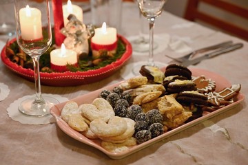 Beautifully set table for Christmas holidays. Candies, candles and Christmas decorations - decorated home on Christmas Eve.