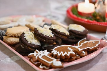 Beautifully set table for Christmas holidays. Candies, candles and Christmas decorations - decorated home on Christmas Eve.