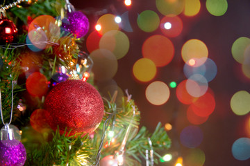 Christmas decoration. Hanging red balls on pine branches christmas tree garland and ornaments over abstract bokeh background with copy space.