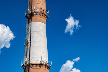 Brick chimney of a factory boiler room. Brick chimney with red and white stripes