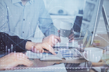 Multi exposure of chart with man typing on computer in office on background. Concept of hard work.