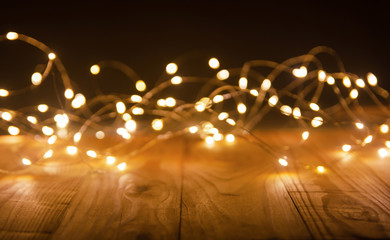 Defocus christmas lights on wooden background. selective focus on wood planks